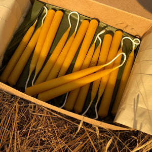 beeswax candles in a box are illuminated in the sun