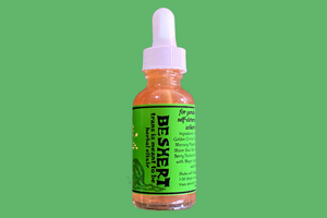 a tincture bottle with a green label featuring the text BESHERT trans is meant to be herbal elixir on a moss green background
